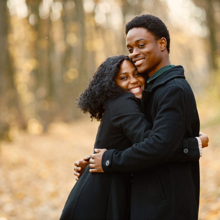 Loving black couple walking in park and enjoying autumn day